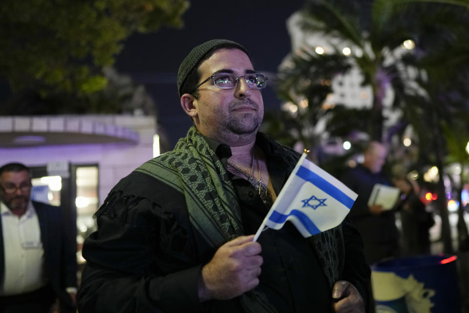 A man holds an Israel flag as he attends an event commemorating Kristallnacht, the 1938 government-backed pogroms against Jews in Germany and Austria, at the Holocaust Memorial in Miami Beach, Fla., Sunday, Nov. 5, 2023. (AP Photo/Rebecca Blackwell)