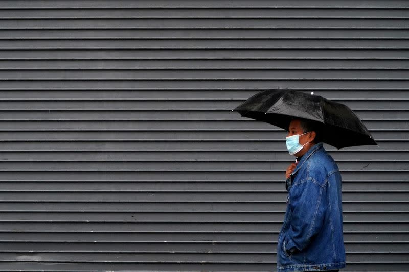 A man walks in the rain with an umbrella in the Manhattan borough of New York City