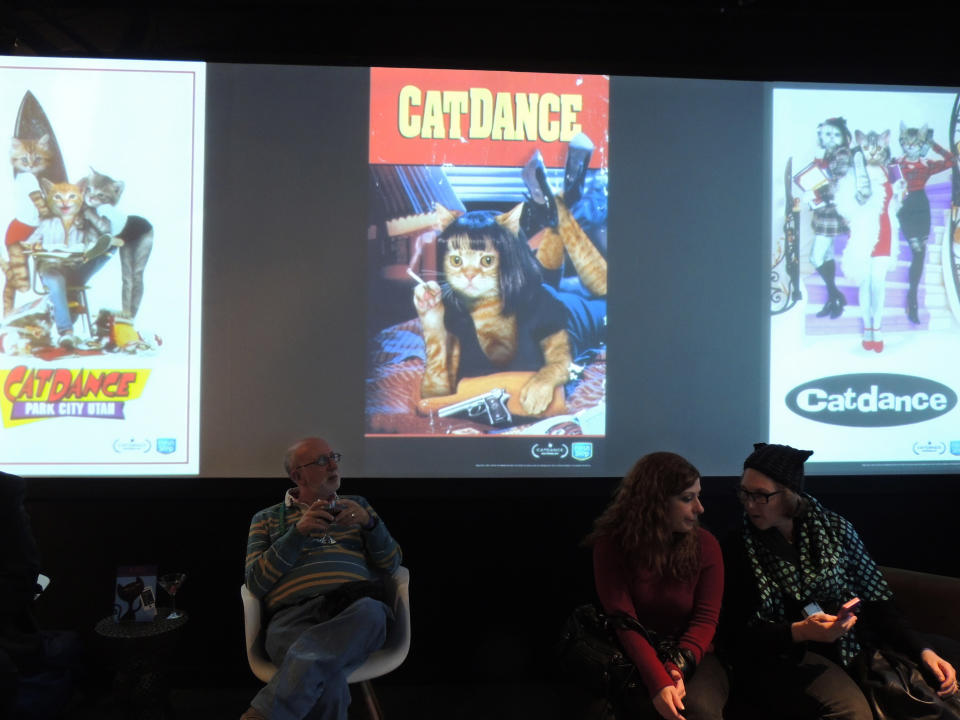 In this Saturday, Jan. 19, 2013 photo, attendees of "Catdance" sit among cat-inspired spoofs of movie posters at the Sundance Film Festival in Park City, Utah. (AP Photo/Nekesa Mumbi Moody)