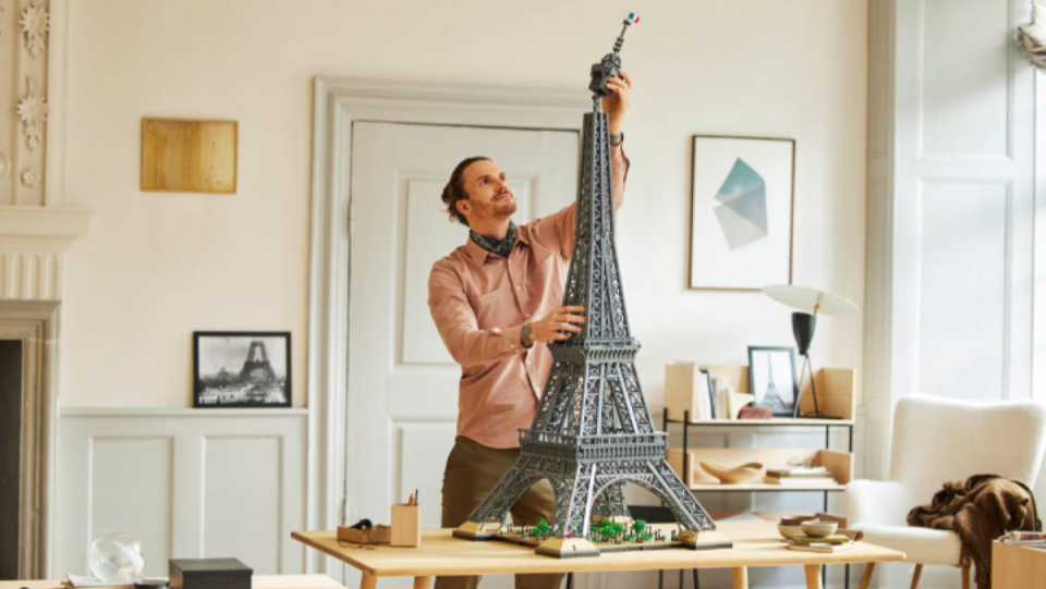 A man assembles the LEGO Eiffel Tower build