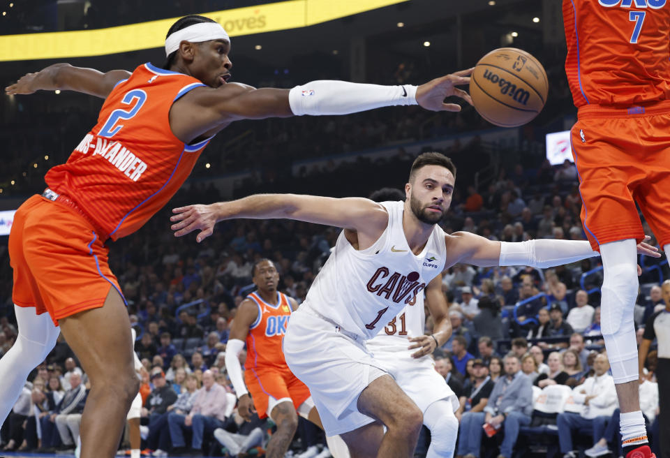 Nov 8, 2023; Oklahoma City, Oklahoma, USA; Oklahoma City Thunder guard Shai Gilgeous-Alexander (2) and Cleveland Cavaliers guard Max Strus (1) reach for a loose ball during the first quarter at Paycom Center. Mandatory Credit: Alonzo Adams-USA TODAY Sports