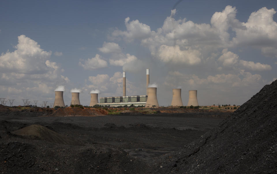 The coal-powered Duvha power station, near Emalahleni (formerly Witbank) east of Johannesburg, Thursday, Nov. 17, 2022 is seen on the horizon. Living in the shadow of one of South Africa’s largest coal-fired power stations, residents of Masakhane fear job losses if the facility is closed as the country moves to cleaner energy. A significant polluter because it relies on coal to generate about 80% of its electricity, South Africa plans to reduce that to 59% by 2030 by phasing out some of its 15 coal-fired power stations and increasing its use of renewable energy. (AP Photo/Denis Farrell)