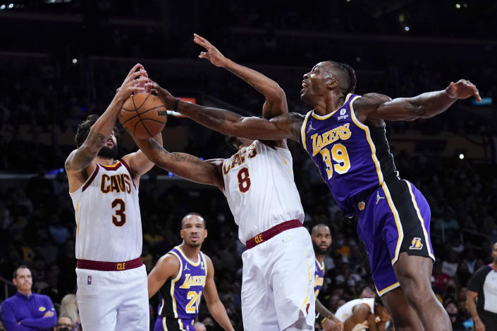 Los Angeles Lakers' Dwight Howard, right, fights for a rebound with Cleveland Cavaliers' Ricky Rubio, left, and Lamar Stevens during the first half of an NBA basketball game Friday, Oct. 29, 2021, in Los Angeles. (AP Photo/Jae C. Hong)