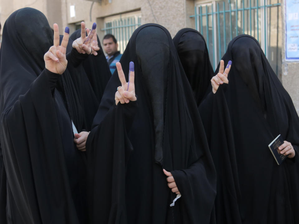 Iraqi women give the victory signs while showing their inked fingers after casting votes at a polling center in Baghdad, Iraq, Wednesday, April 30, 2014. A key election for a new Iraqi parliament was underway on Wednesday amid a massive security operation as the country continued to slide deeper into sectarian violence more than two years after U.S. forces left the country. (AP Photo/Khalid Mohammed)