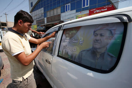 FILE PHOTO: A Kurdish man decorates a car with a poster bearing the image of Iraq's Kurdistan region's President Massoud Barzani, urging people to vote in the September 25th independence referendum, in Erbil, Iraq September 5, 2017. REUTERS/Azad Lashkari