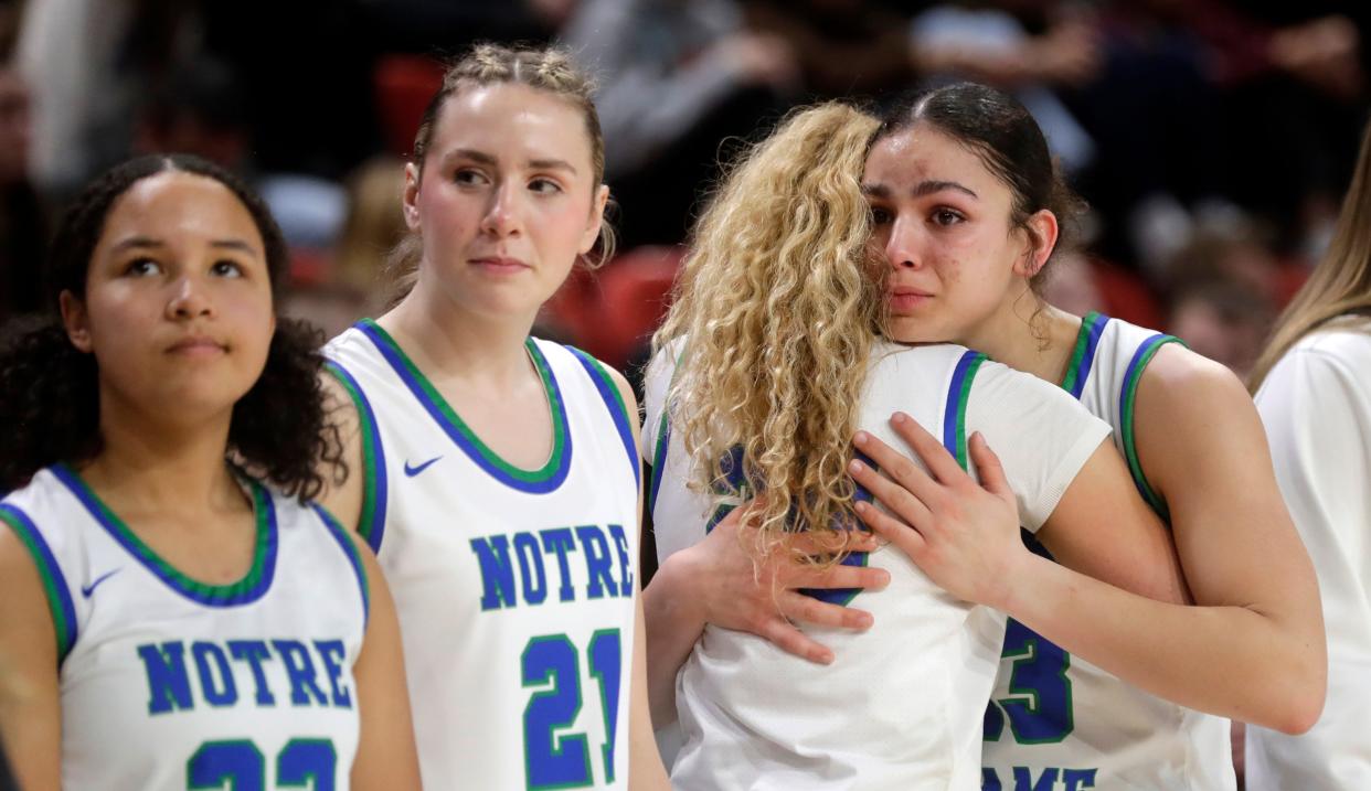 Green Bay Notre Dame's Kaia Waldrop (13) gets a hug after the team lost to Pewaukee in the WIAA Division 2 state championship Saturday at the Resch Center.