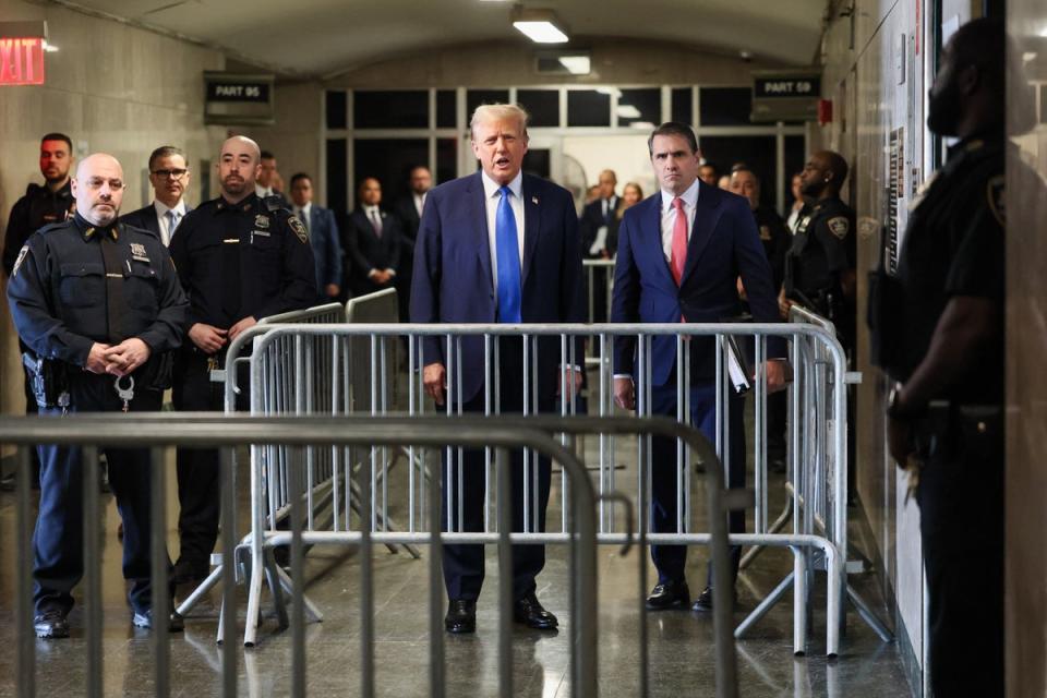 Donald Trump speaks to reporters from a Manhattan criminal court hallway on 22 April (Getty)