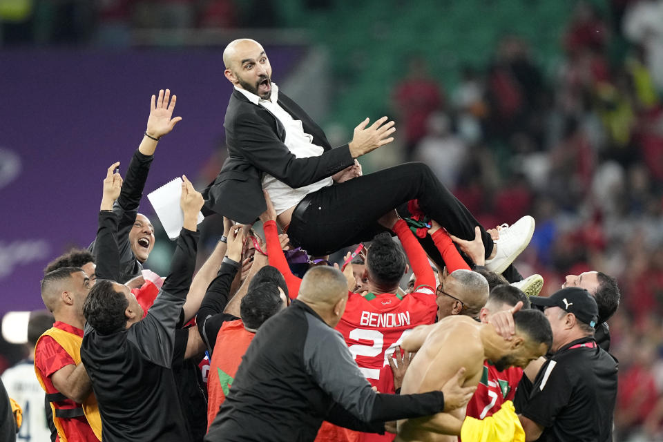El técnico de Marruecos Walid Regragui es alzado por los jugadores tras la victoria 1-0 ante Portugal en los cuartos de final del Mundial, el sábado 10 de diciembre de 2022, en Doha, Qatar. (AP Foto/Martin Meissner)