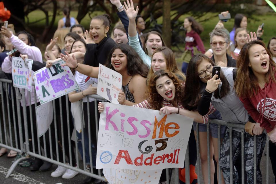 FILE - In this April 15, 2019, file photo, Wellesley College students cheer as runners from the 123rd Boston Marathon pass by in Wellesley, Mass. Due to the COVID-19 virus pandemic, the 124th running of the Boston Marathon was postponed from its traditional third Monday in April to Monday, Sept. 14, 2020. (AP Photo/Steven Senne, File)