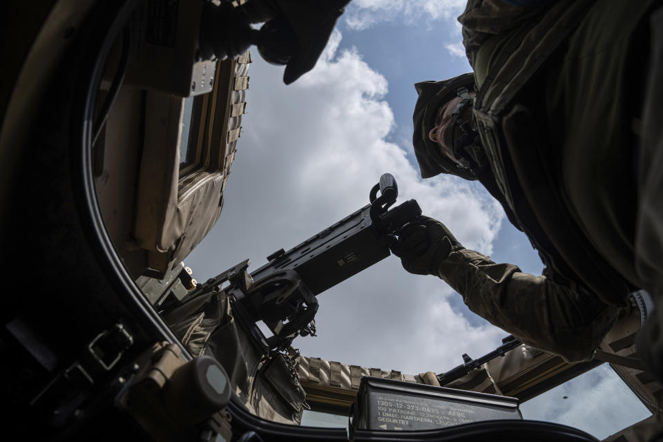 A Ukrainian serviceman of the 68th Oleksa Dovbush hunting brigade aims a machine gun during a patrol in the recently retaken village of Blahodatne, Ukraine, Saturday, June 17, 2023. (AP Photo/Evgeniy Maloletka)