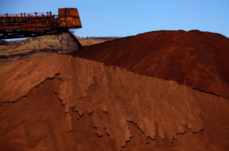 FILE PHOTO: A stacker unloads iron ore onto a pile at a mine located in the Pilbara region of Western Australia