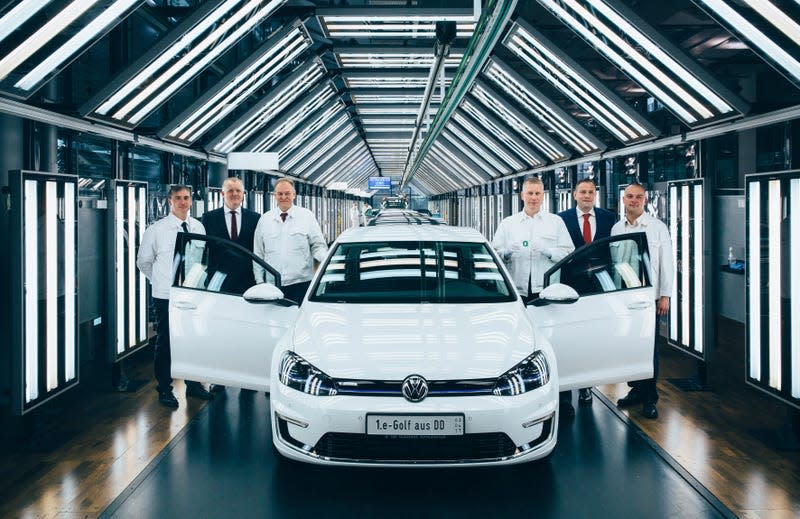 Engineers and executives posing with a white VW e-Golf