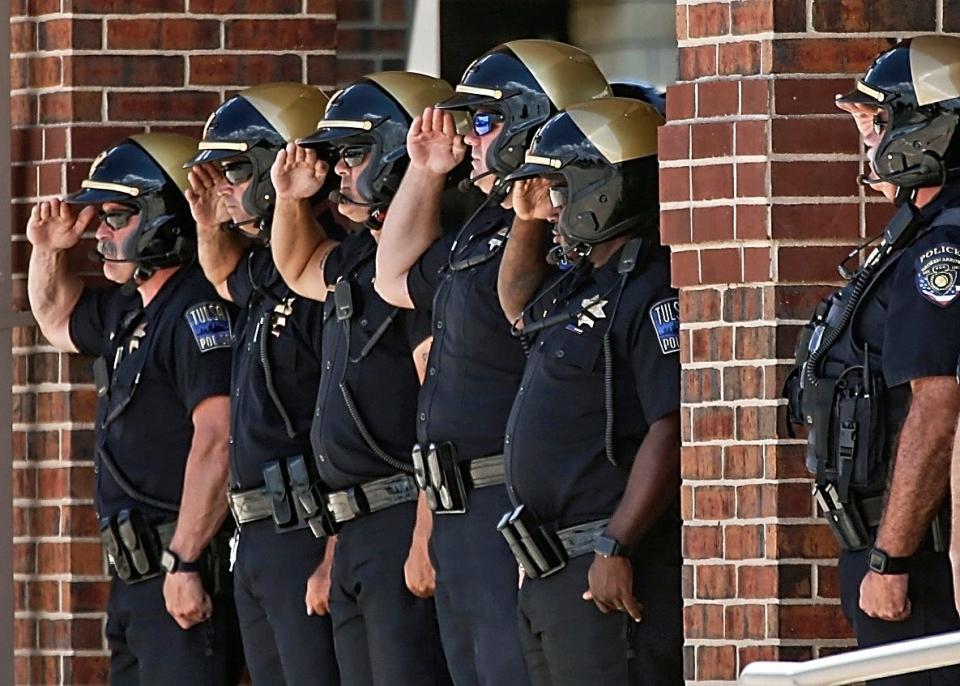 Police officers from various departments throughout the state salute Edmond police Sgt. C.J. Nelson as his casket is loaded after Monday's funeral at Crossings Community Church.