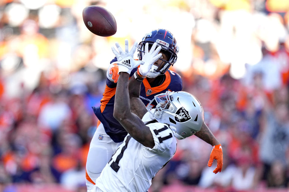 Las Vegas Raiders wide receiver Henry Ruggs III (11) pulls in a pass as Denver Broncos cornerback Ronald Darby defends during the second half of an NFL football game, Sunday, Oct. 17, 2021, in Denver. (AP Photo/Jack Dempsey)
