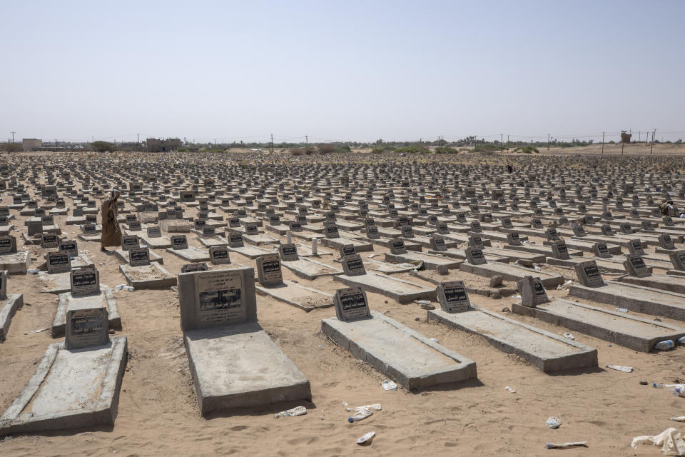 A man walks in a mass graveyard where hundreds of Yemeni fighters are buried in Marib, Yemen, Monday, June 21, 2021. On the most active front line in Yemen's long civil war, the months-long battle for the city of Marib has become a dragged-out grind with a steady stream of dead and wounded from both sides. (AP Photo/Nariman El-Mofty)