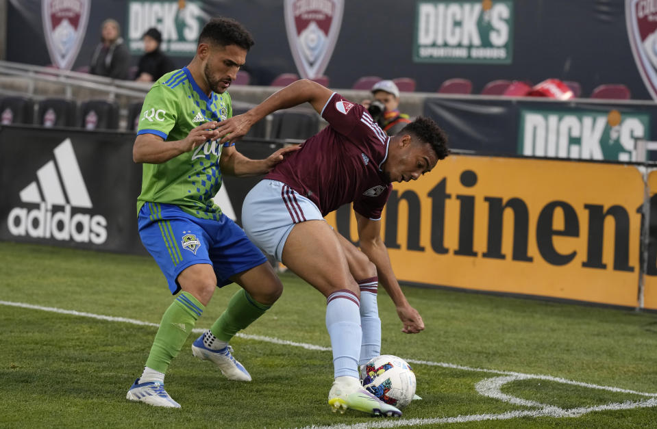 Seattle Sounders midfielder Cristian Roldan, left, fights for control of the ball with Colorado Rapids forward Jonathan Lewis in the second half of an MLS soccer match Sunday, May 22 2022, in Commerce City, Colo. (AP Photo/David Zalubowski)