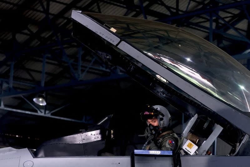 Fighter pilot Yen Hsiang-sheng sits inside an F-16V fighter jet wearing a Joint Helmet Mounted Cueing System helmet