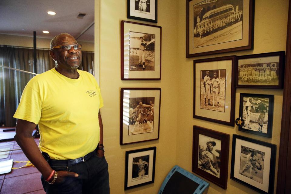 In this March 13, 2014 photo, Dusty Baker looks at walls covered with old photographs of players and teams that impacted him in the gymnasium of his home in Granite Bay, Calif. Out of uniform for the first time since taking 2007 off between managerial jobs with the Cubs and Reds, Baker is not slowing down much from his pressure-packed days in the dugout. (AP Photo/Eric Risberg)