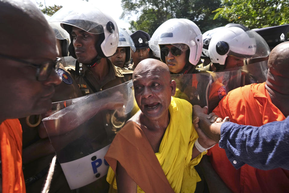 A Sri Lankan Buddhist monk scuffles with policemen outside the parliament during a protest against president Ranil Wickremesinghe's policy speech at the parliament in Colombo, Sri Lanka on Wednesday, Feb. 8, 2023. Wickremesinghe on Wednesday appealed for patience amid the country's worst economic crisis but promised brighter times ahead. (AP Photo/Eranga Jayawardena)