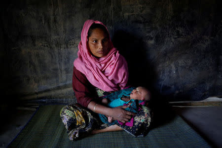Amina, 30, holds her 16-day-old daughter Sumaiya as she poses for a photograph inside their shelter in Balukhali unregistered refugee camp in Cox’s Bazar, Bangladesh, February 8, 2017. REUTERS/Mohammad Ponir Hossain