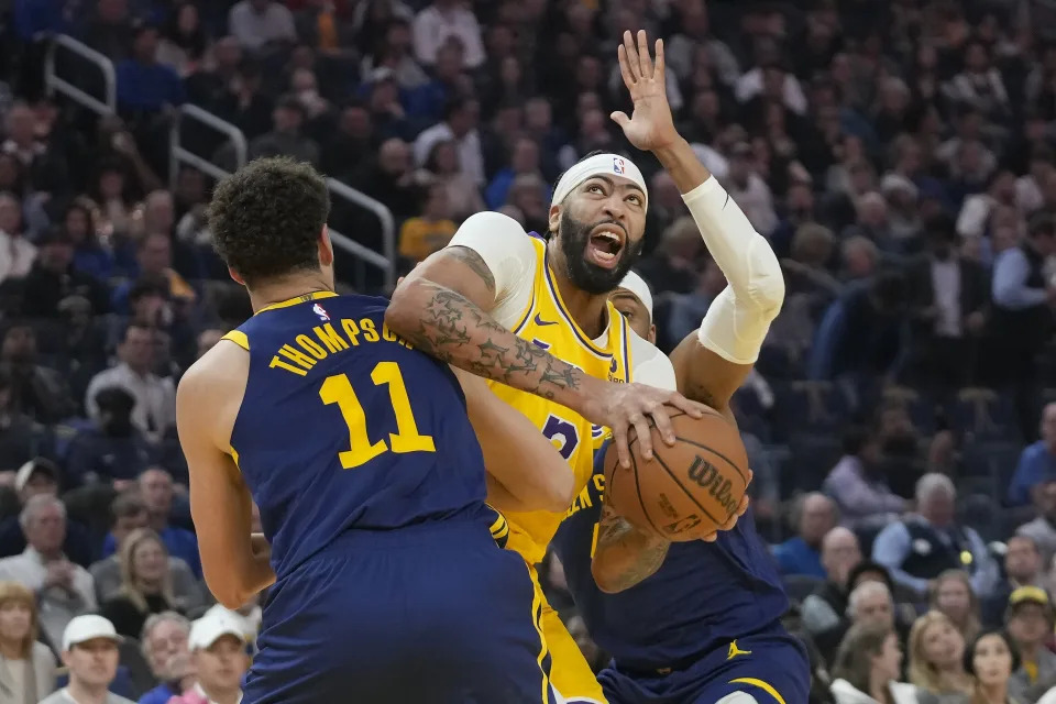 Los Angeles Lakers forward Anthony Davis, middle, is fouled by Golden State Warriors guard Klay Thompson (11) as guard Moses Moody, rear, defends during the first half of an NBA basketball game in San Francisco, Thursday, Feb. 22, 2024. (AP Photo/Jeff Chiu)