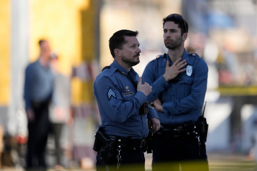 Law enforcement officers look around the scene after an incident following the Kansas City Chiefs victory parade in Kansas City, Mo., Wednesday, Feb. 14, 2024. The Chiefs defeated the San Francisco 49ers Sunday in the NFL Super Bowl 58 football game. (AP Photo/Charlie Riedel)