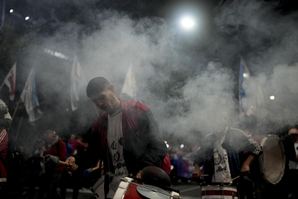 A man plays the drum as people gather to honor Argentina's late former first lady Maria Eva Duarte de Peron, better known as "Evita" outside the Social Development Ministry building in Buenos Aires, Argentina, Tuesday, July 26, 2022. Argentines commemorate the 70th anniversary of the death of their most famous first lady Evita who died of cancer on July 26, 1952, at the age of 33. (AP Photo/Natacha Pisarenko)