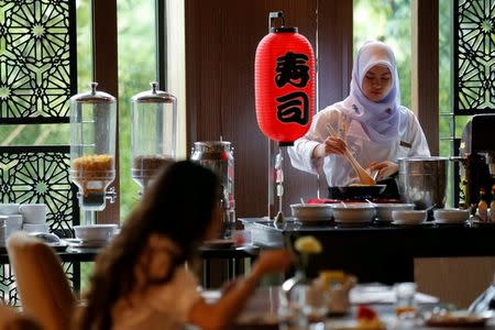 A Muslim employee cooks as a visitor has breakfast at the Al Meroz hotel in Bangkok, Thailand, August 29, 2016. REUTERS/Chaiwat Subprasom