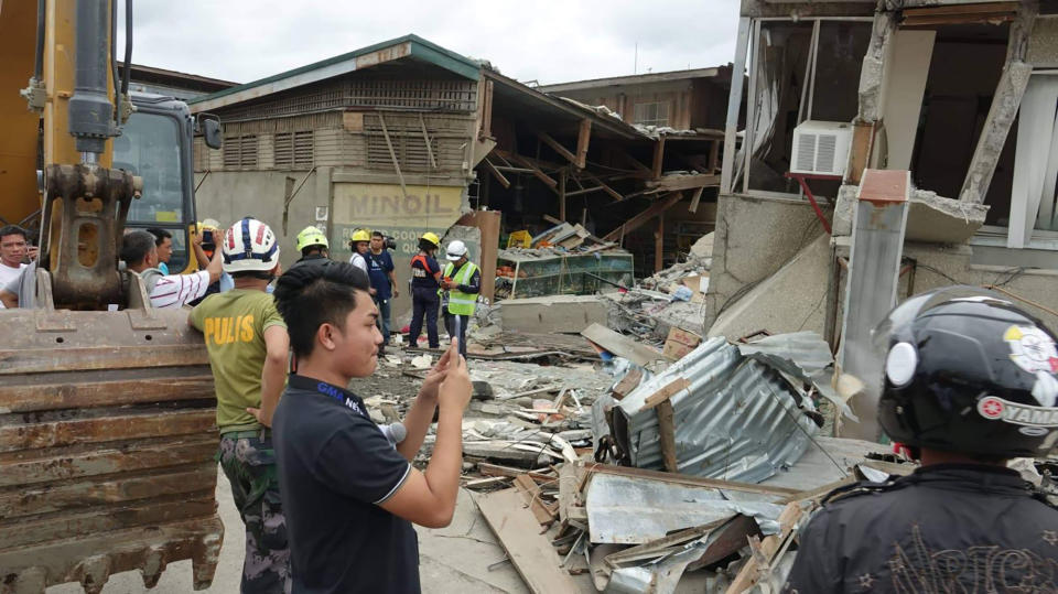 Residents and rescuers check damaged structures following an earthquake that struck Padada, Davao del Sur province, southern Philippines on Sunday Dec. 15, 2019. A strong quake jolted the southern Philippines on Sunday, causing a three-story building to collapse and prompting people to rush out of shopping malls, houses and other buildings in panic, officials said. (AP Photo)