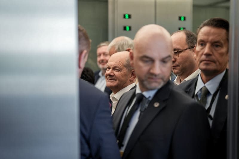 German Chancellor Olaf Scholz (C) stands next to SPD parliamentary group members and security officials in the elevator after the special session of the SPD parliamentary group in the Bundestag. The coalition leaders have reached an agreement on the new budget after lengthy negotiations. Kay Nietfeld/dpa