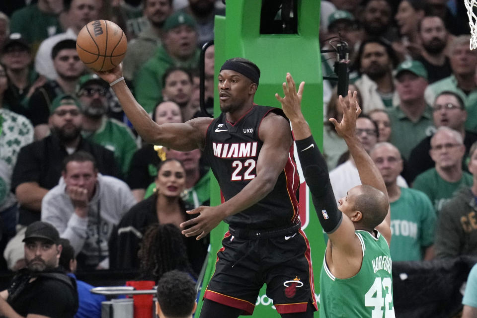 Miami Heat forward Jimmy Butler, left, passes while under pressure from Boston Celtics center Al Horford during the first half in Game 7 of the NBA basketball Eastern Conference finals Monday, May 29, 2023, in Boston. (AP Photo/Charles Krupa )