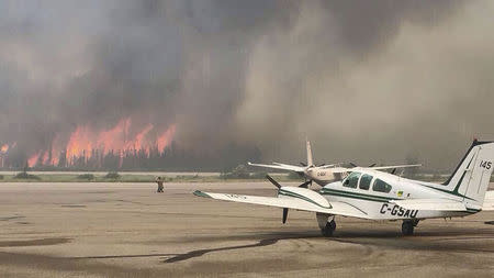 Flames from a forest fire approach the airport outside the town of La Ronge, Saskatchewan in a picture released by the Prince Albert Fire Department July 5, 2015. REUTERS/Prince Albert Fire Department/Handout via Reuters