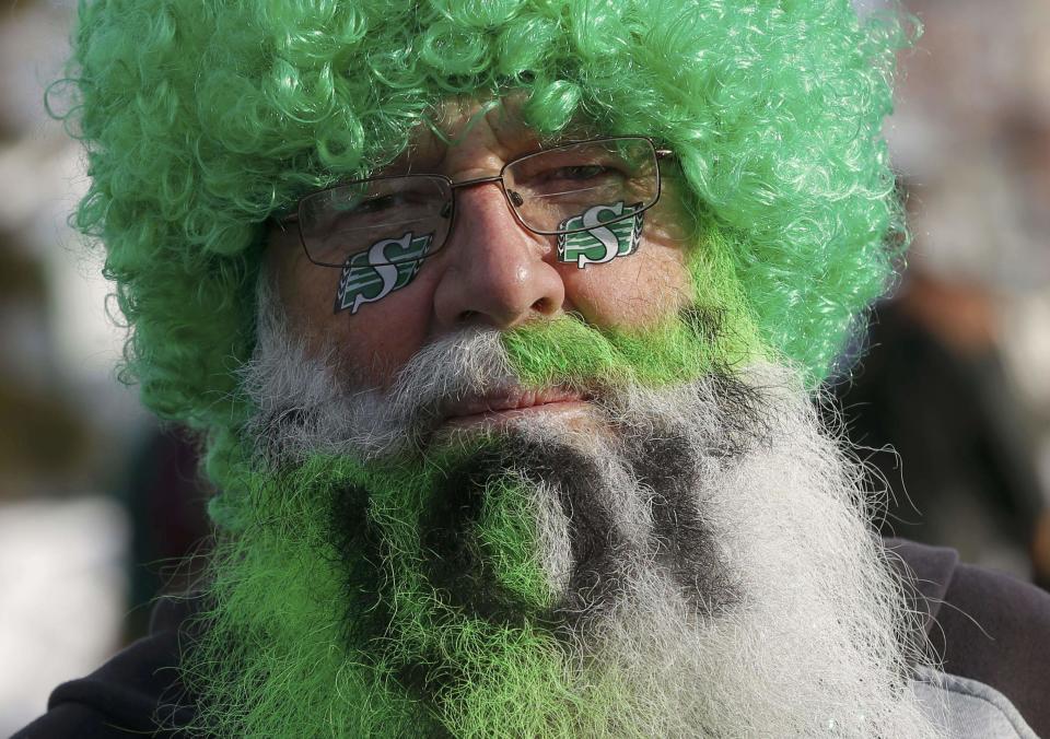 A Saskatchewan Roughrider fan dressed up in a wig and painted beard gets ready for the 101st Grey Cup game between the Saskatchewan Roughriders and the Hamilton Tiger Cats in Regina