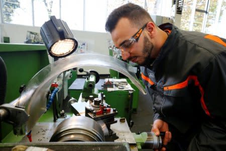 FILE PHOTO: Trainee Mohammad Alhalabi, a 22-year-old refugee from Syria works with a miller at the training workshop of Ford Motor Co in Cologne, Germany, November 3, 2016. Alhalabi is one of 24 trainees of Ford Germany's so-called EQ qualification program to integrate new employees in a booming labour market.    REUTERS/Wolfgang Rattay/File Photo