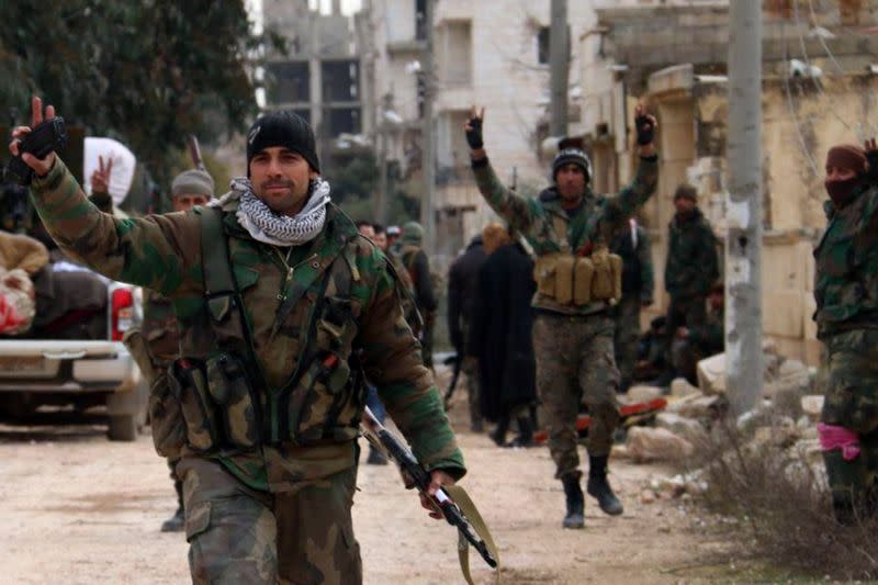 Syrian army soldiers gesture in al-Rashideen area in Aleppo province