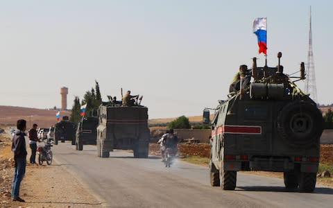 A convoy of Russian military vehicles drives toward the northeastern city of Kobane - Credit: AFP