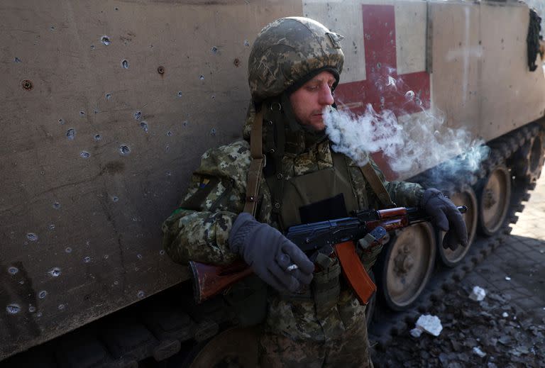 Un militar ucraniano fuma junto a un vehículo blindado de transporte médico en Bajmut, región de Donetsk, el 26 de enero de 2023, en medio de la invasión rusa de Ucrania.