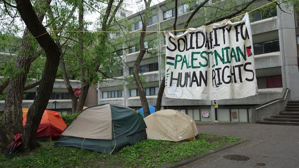 Signs, posters and banners calling for divestment could be seen among the tents outside Richardson Hall at Queen's University on May 13, 2024.