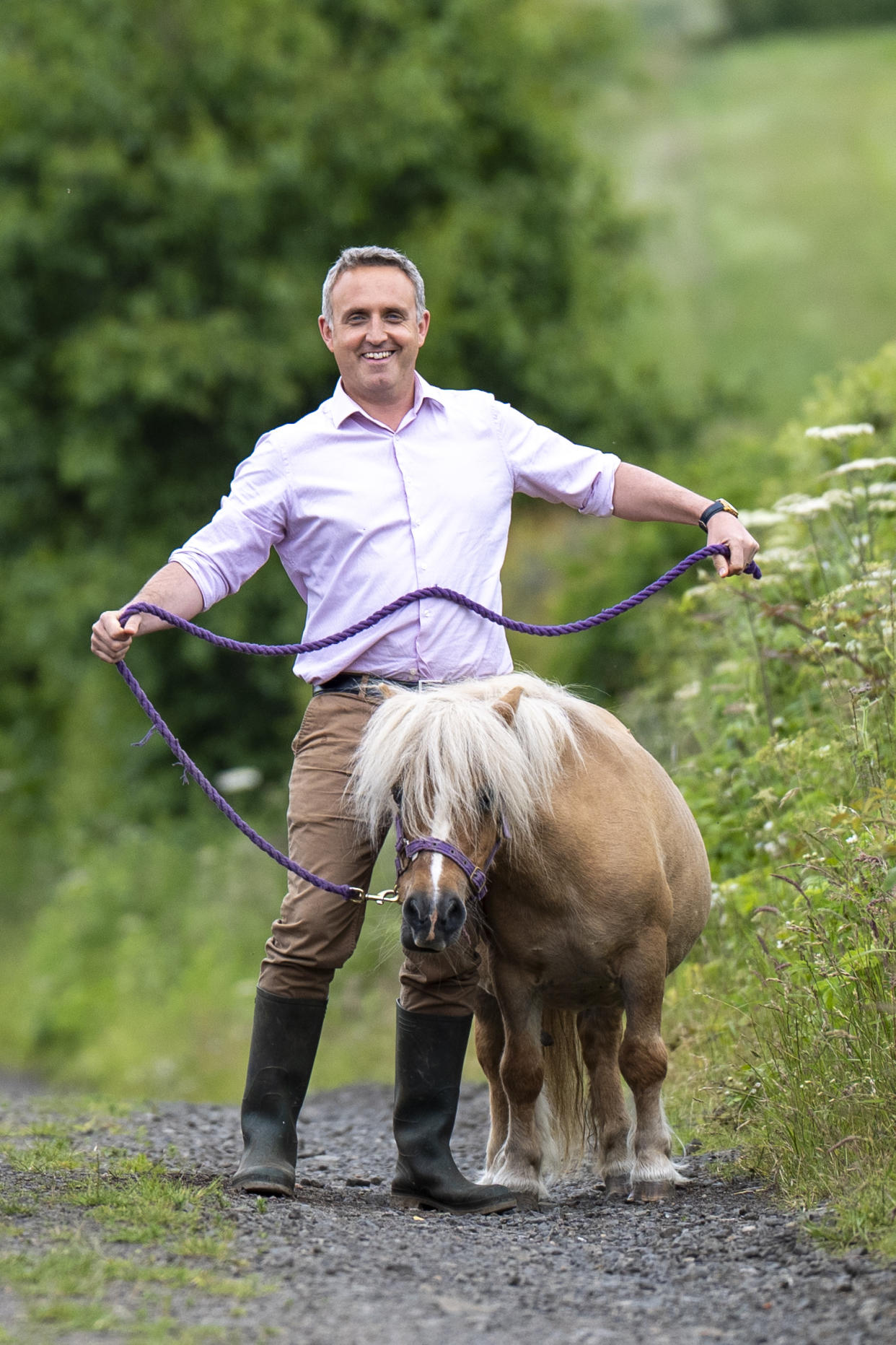 Scottish Liberal Democrat leader Alex Cole-Hamilton horses about with Cammie the pony – which later stood on his foot – during a visit to Craigie’s Farm in South Queensferry (Jane Barlow/PA)