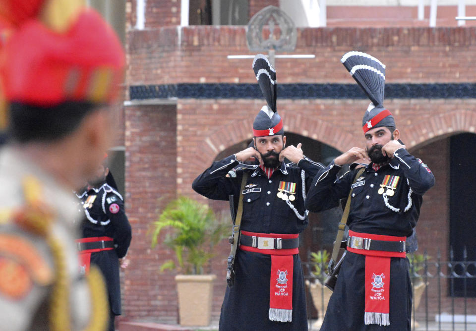 FILE- In this Friday, Aug. 9, 2019, file photo, Pakistan Rangers soldiers face Indian Border Security Force soldiers at a daily closing ceremony on the Indian side of the Attari-Wagah border. India's recent clampdown has a long history in Kashmir and the conflict has existed since the late 1940s, when India and Pakistan won independence from the British empire and began fighting over rival claims to the Muslim-majority territory. India and Pakistan have fought two of their three subsequent wars over Kashmir, and each administers a portion of the region. India has long seen the Kashmiri struggle for self-determination as Islamabad's proxy war against New Delhi. (AP Photo/Prabhjot Gill, File)