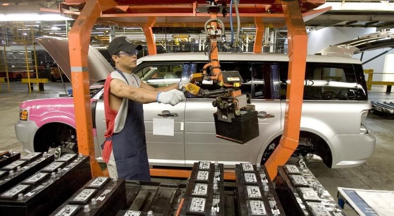 Worker Nick Aphayvong prepares to install a battery into a Ford Flex on the assembly line at the company's Oakville Plant June 3, 2008. REUTERS/Fred Thornhill