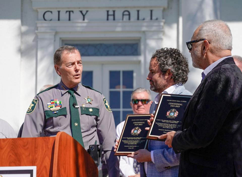 Sheriff Kevin Rambosk presents centennial plaques to Sheriff William Riley Maynard's grandson, Wayne Maynard, and great-grandson, Ryan Maynard, at Everglades City Hall in Everglades City on Monday, Jan. 9, 2023. According to the Sheriff's office, Sheriff Maynard maintained "law and order across the wild and rugged Collier County landscape from 1923 to 1928 with the help of one sworn deputy and his wife Chief Deputy Blanche Maynard."