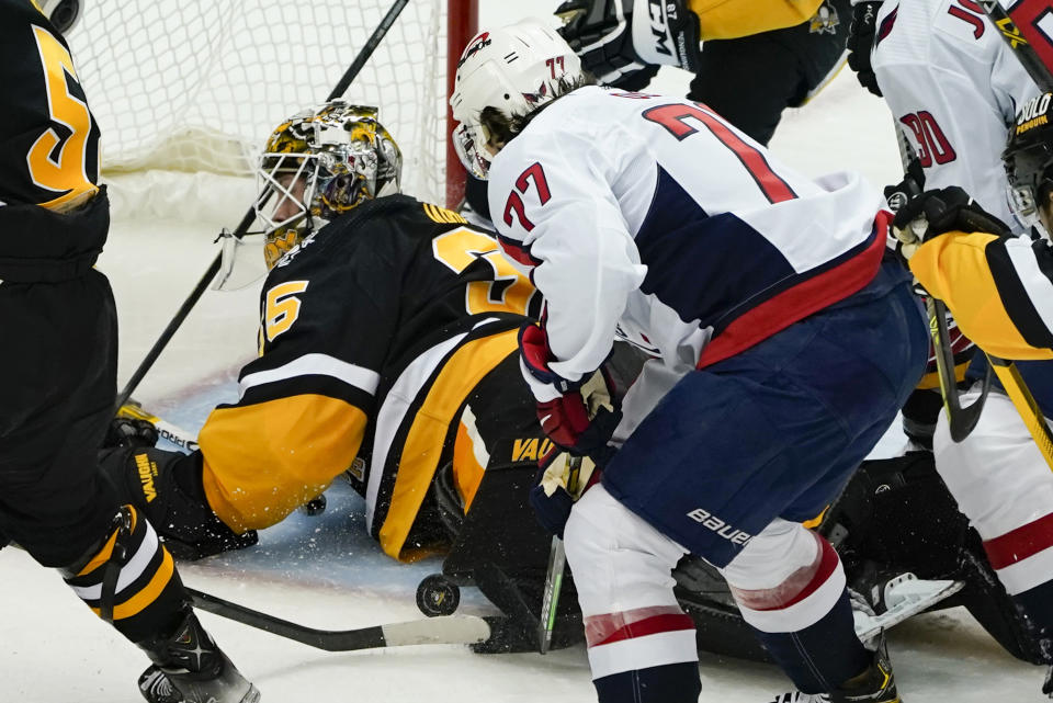 Washington Capitals' T.J. Oshie (77) tries to get to the puck as it slides beside Pittsburgh Penguins goaltender Tristan Jarry during the third period of an NHL hockey game, Saturday, April 9, 2022, in Pittsburgh. The Capitals won 6-3. (AP Photo/Keith Srakocic)