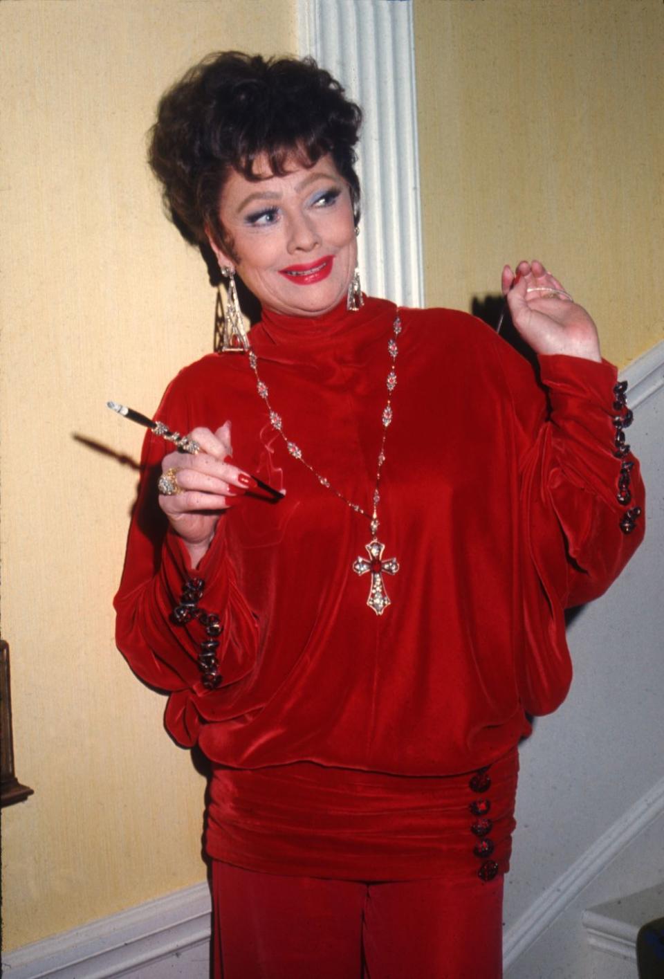 1974: In costume for 'Mame', donning a chic scarlet gown and chunky jewelry.