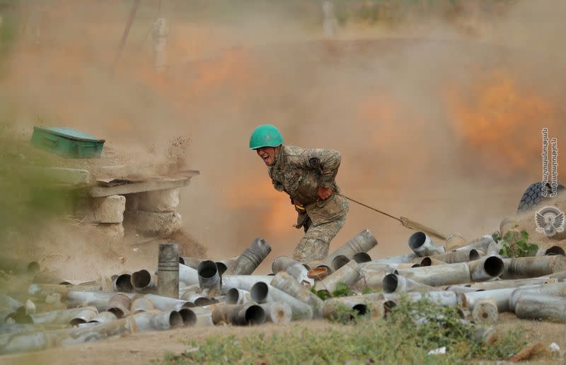 An ethnic Armenian soldier fires an artillery piece during fighting with Azerbaijan's forces in Nagorno-Karabakh