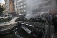 People inspect the site of an explosion in Beirut's southern suburbs January 2, 2014. The powerful explosion in Shi'ite group Hezbollah's southern Beirut stronghold killed three people on Thursday and sent a column of smoke into the sky, a witness said. (REUTERS/Khalil Hassan)