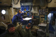 A Russian military cargo plane Il-76 crew member, foreground, works during a flight to the Alexandra Land island of the Franz Josef Land archipelago, Russia, Monday, May 17, 2021. Once a desolate home mostly to polar bears, Russia's northernmost military outpost is bristling with missiles and radar and its extended runway can handle all types of aircraft, including nuclear-capable strategic bombers, projecting Moscow's power and influence across the Arctic amid intensifying international competition for the region's vast resources. (AP Photo/Alexander Zemlianichenko)