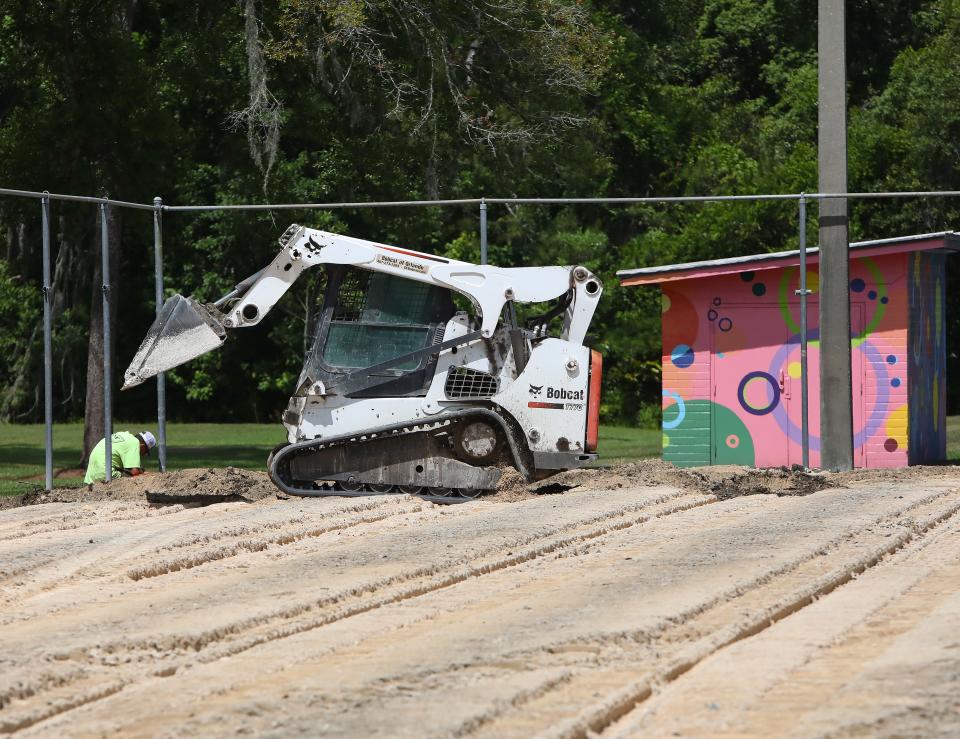 A small front end loader moves dirt as a construction crew works to tear up the surface of the tennis courts at Tom Petty Park as part of a project to reconstruct the courts at the park, in Gainesville FL. May 16, 2022. Renovations began in early May with monies from the Wild Spaces & Public Places half-cent sales tax. The tennis courts will be closed until construction is completed in August 2022.   [Brad McClenny/The Gainesville Sun] 