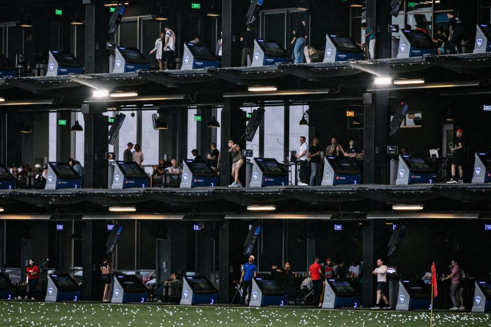 Three stories of driving range bays at Topgolf.