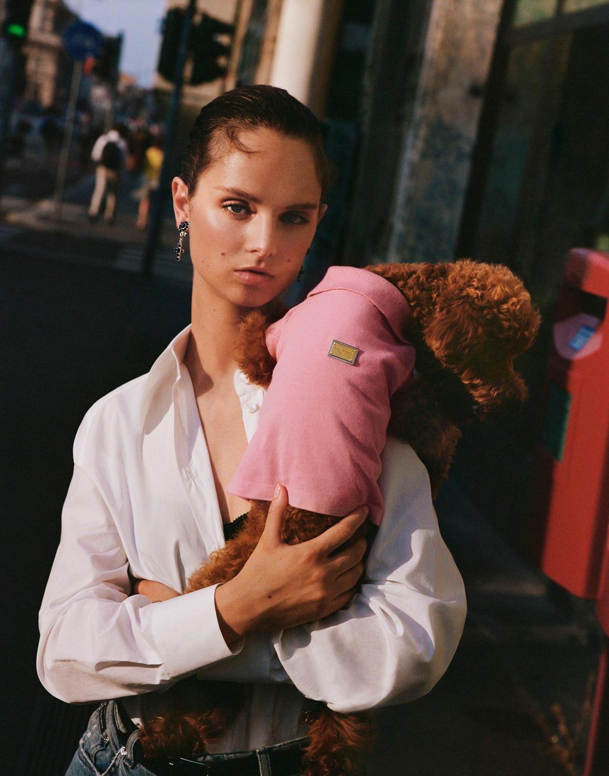 A dog models a pink body suit for the brand